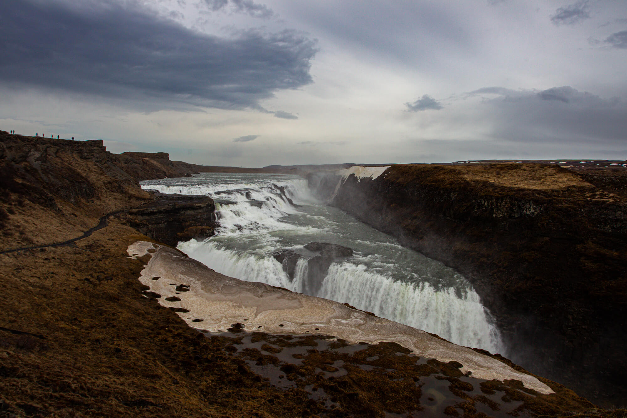 De waterval Gullfoss in IJsland met een kloof en een donkere wolkenlucht