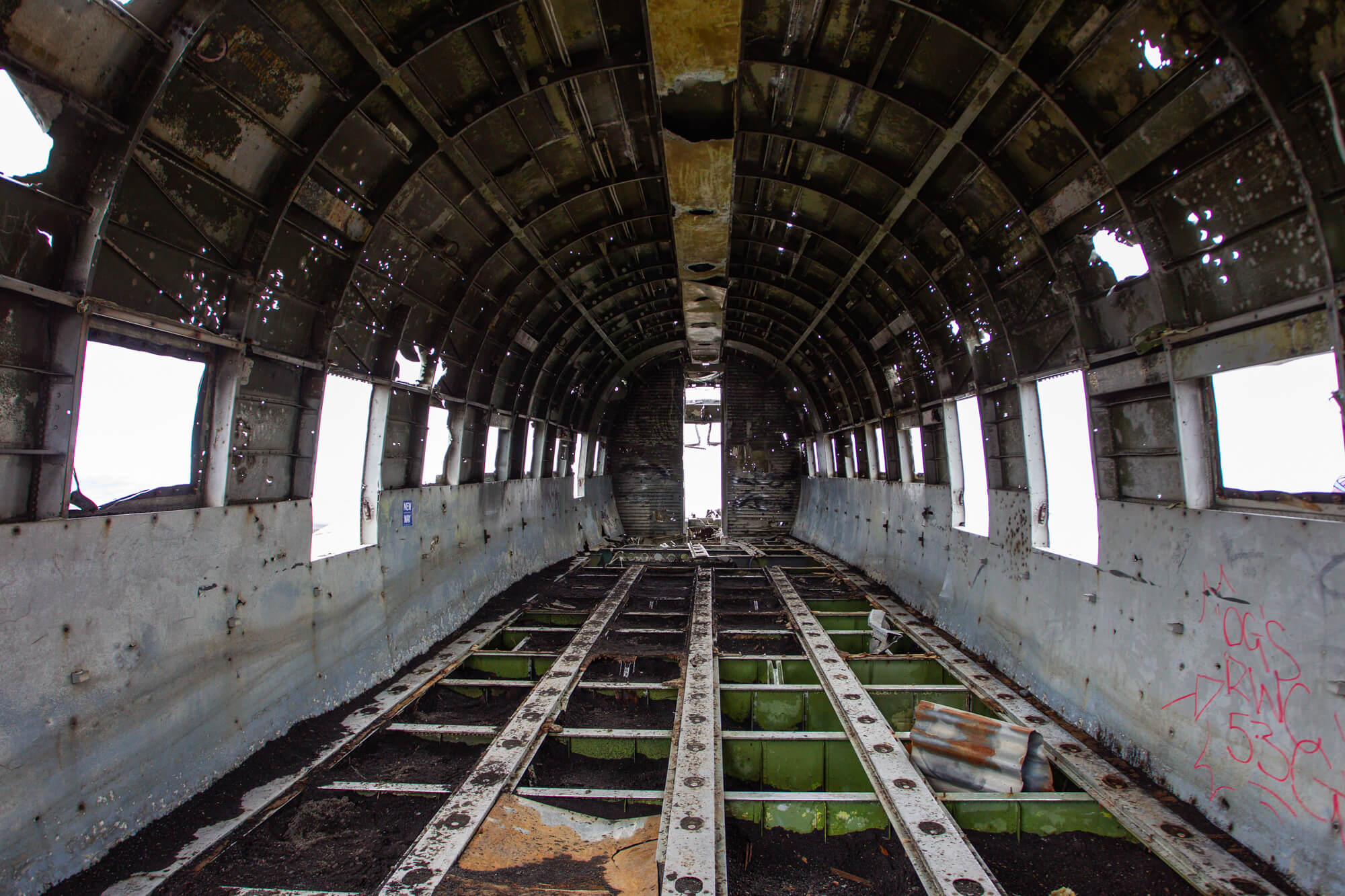De binnenkant van het DC-3 vliegtuigwrak op Sólheimasandur met het kale frame en de ramen