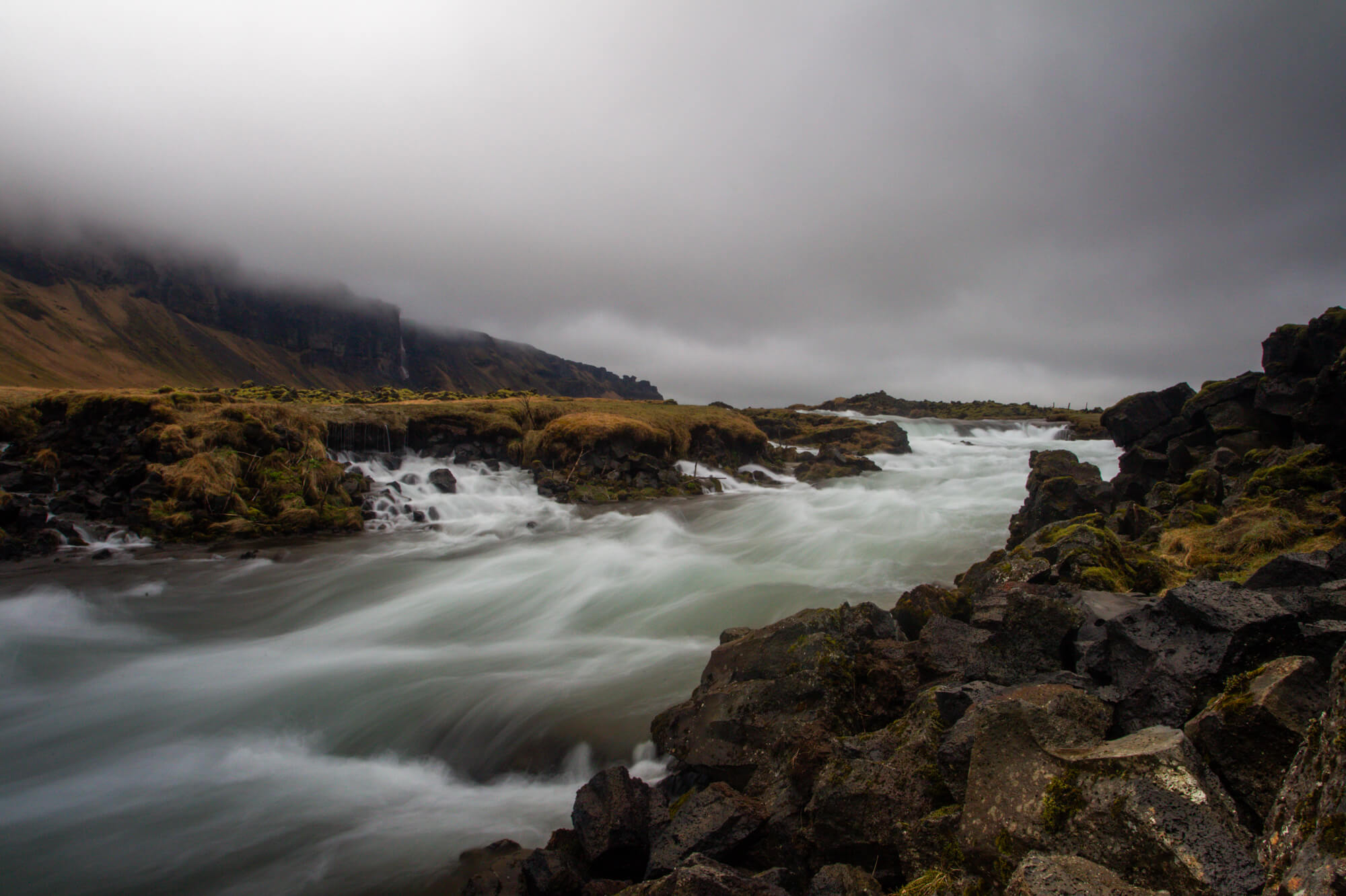 Zijdezacht water van een snelstromende rivier tussen lavarotsen in IJsland